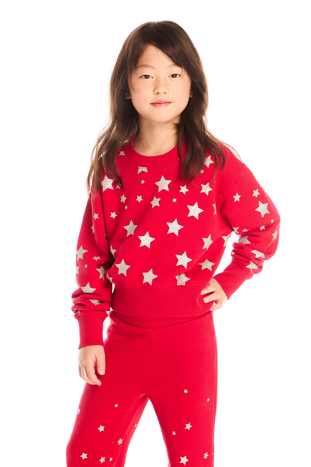Girl wearing Chaser’s Danni Rouge Pullover with star patterns and matching Tara Leggings on a white background