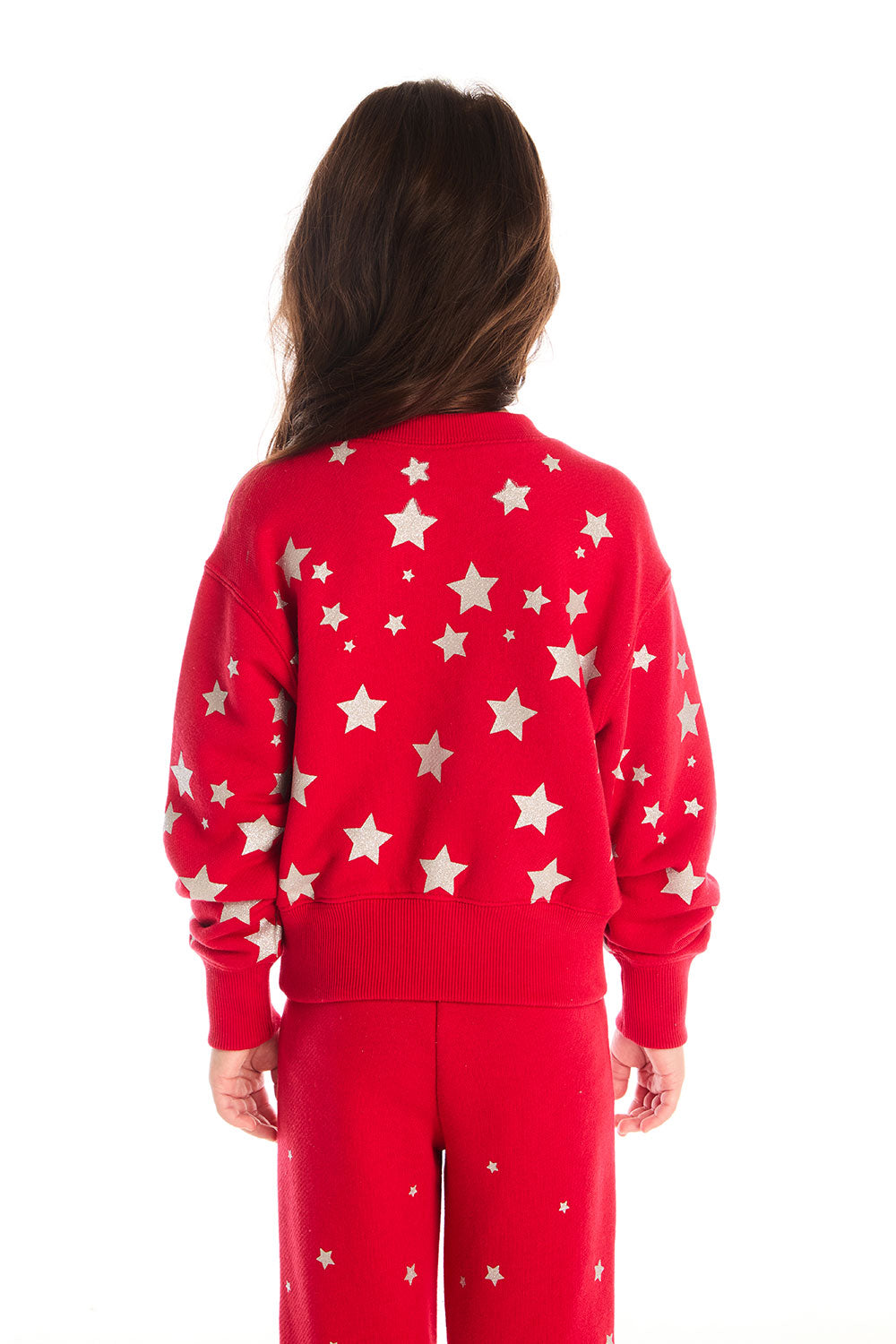 Back view of girl wearing Chaser’s Danni Rouge Pullover with star patterns and matching Tara Leggings on a white background