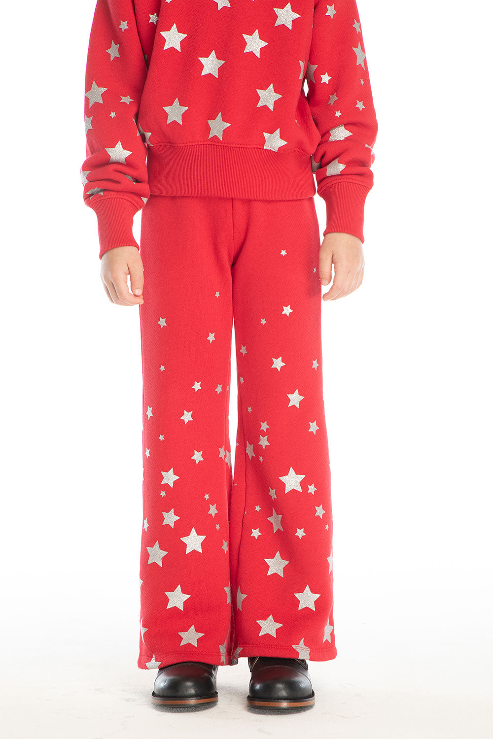 Girl wearing Chaser’s Tara Rouge Leggings with star patterns and matching Danni Rouge Pullover on a white background