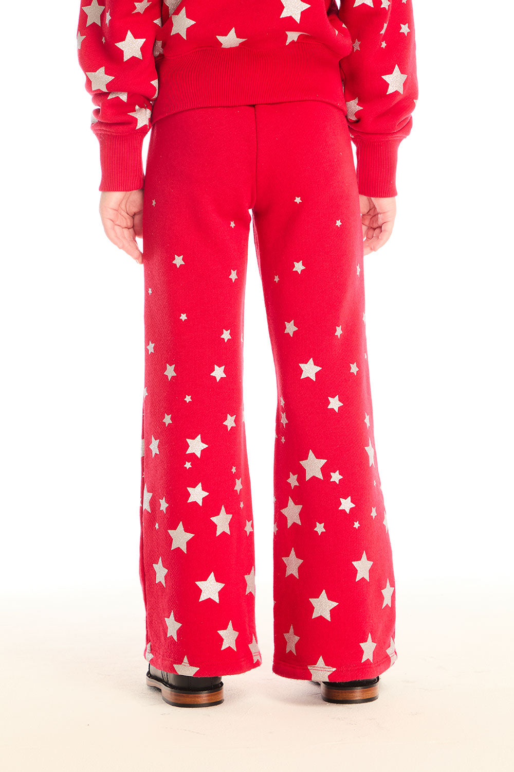 Back view of girl wearing Chaser’s Tara Rouge Leggings with star patterns and matching Danni Rouge Pullover on a white background