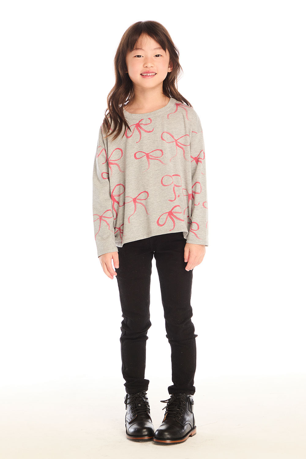  Full body view of girl wearing Chaser’s gray Red Bows Long Sleeve with pink bow pattern and black pants on a white background