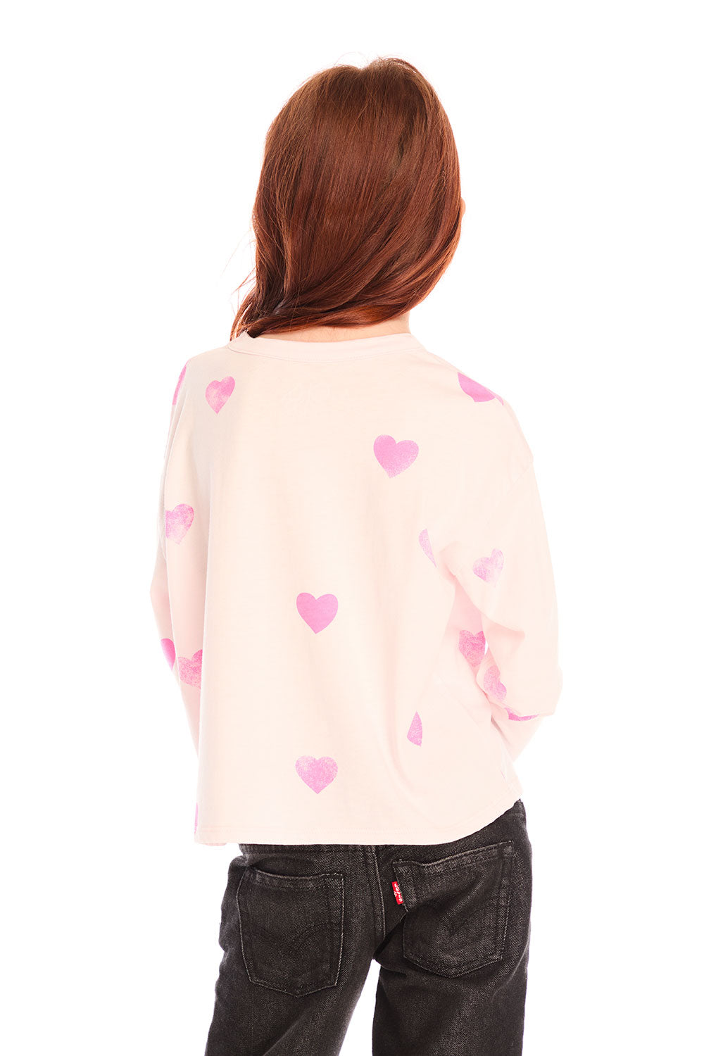 Back view of young girl wearing Chaser’s Allover Hearts light pink pullover with heart patterns on a white background