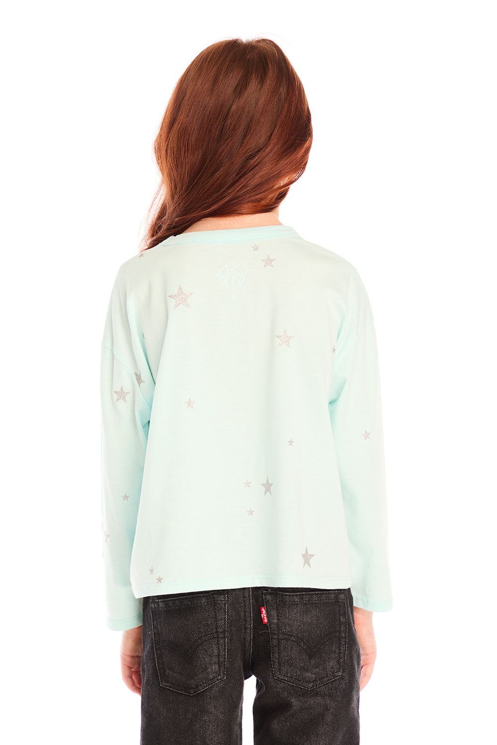 Back view of young girl wearing Chaser’s Ciao Allover Stars light green pullover with light grey star patterns and dark jeans on a white background