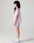 Full body side view of a girl wearing the Chaser  Flutter Butterfly Shorts and matching shirt on a neutral background