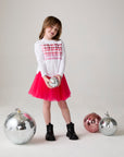 Model wearing Chaser's Merry Girls Long Sleeve Tee in white with holiday lettering, editorial view