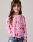 Model wearing Chaser's Yummy Holidays Girls Long Sleeve Tee in camelia pink with holiday treat print, front view