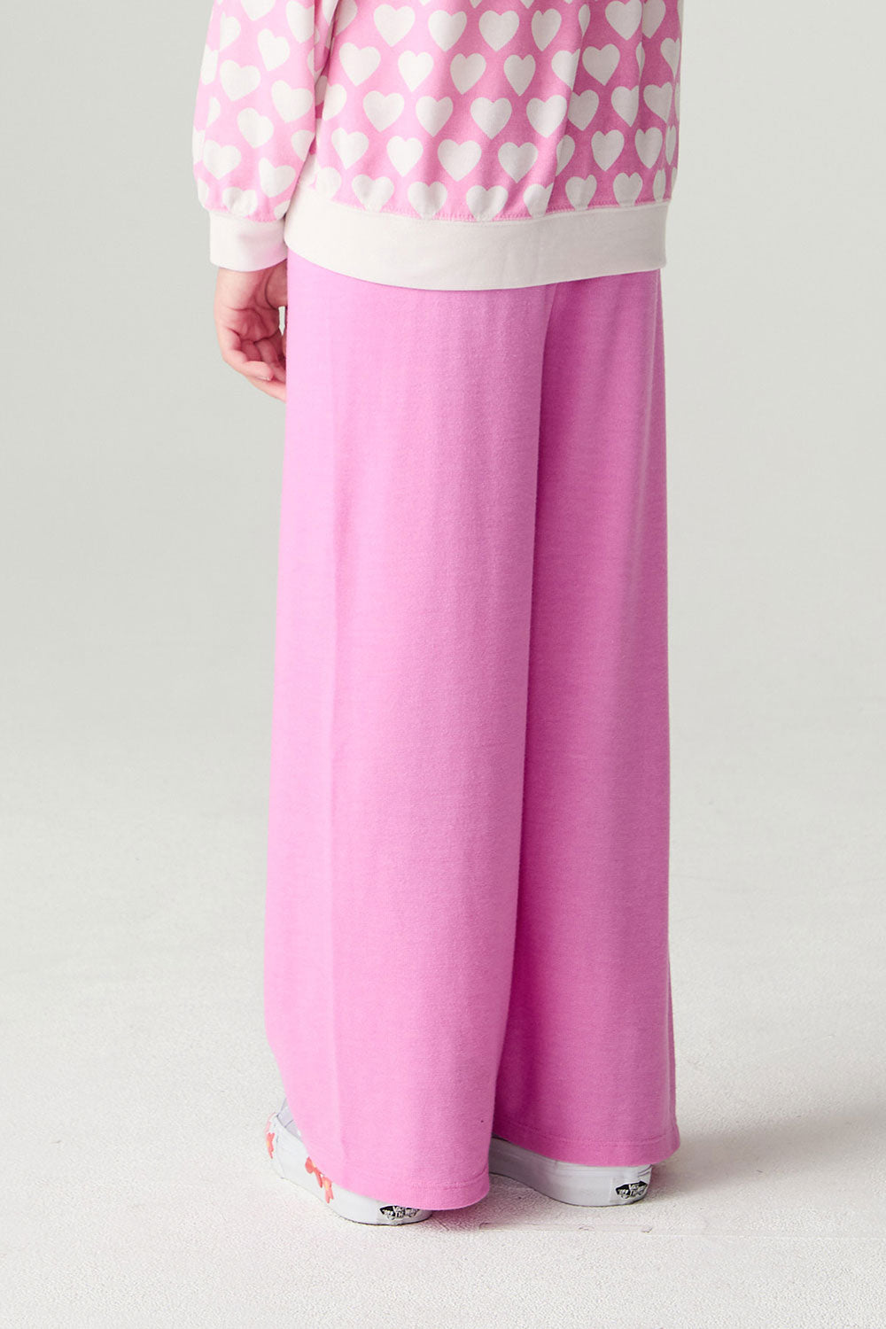 Back view of a girl wearing the Chaser Love Is Everywhere Girls Pants Jogger with matching pink pants