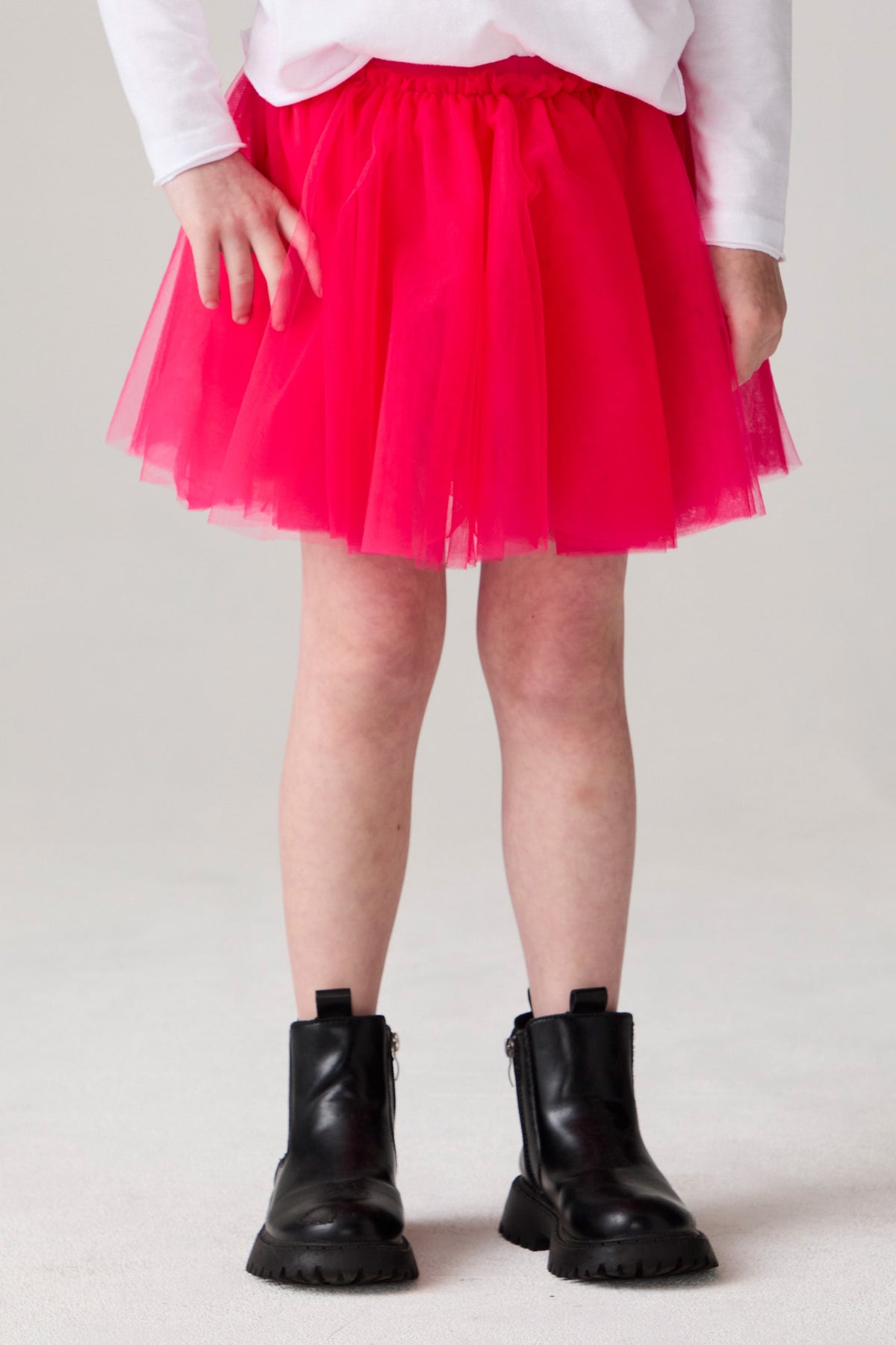 Model wearing Chaser's Holiday Ombre Girls Tulle Skort in hot bubble gum with distinctive graphic and design details, front view