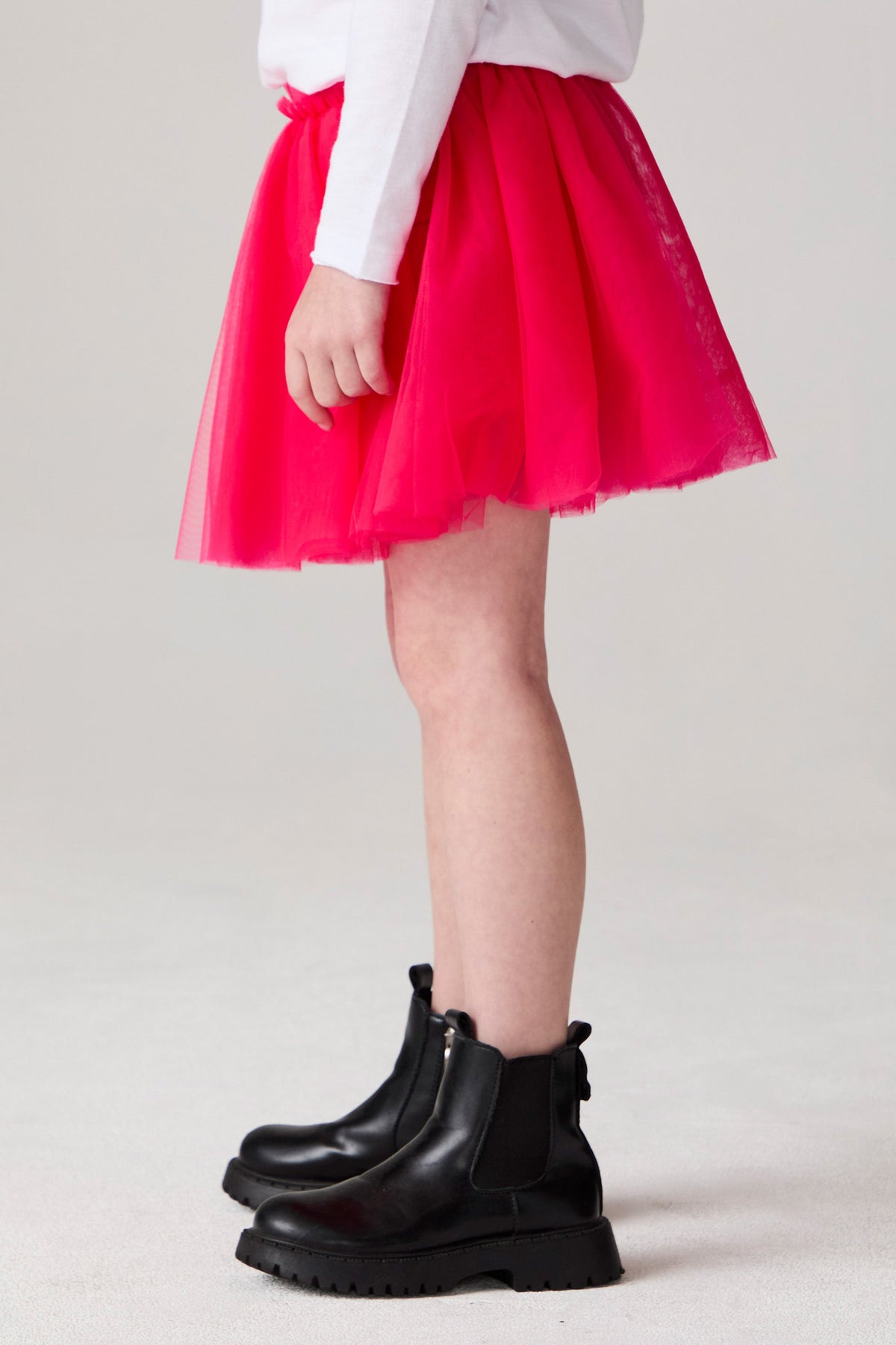 Model wearing Chaser's Holiday Ombre Girls Tulle Skort in hot bubble gum with distinctive graphic and design details, side view