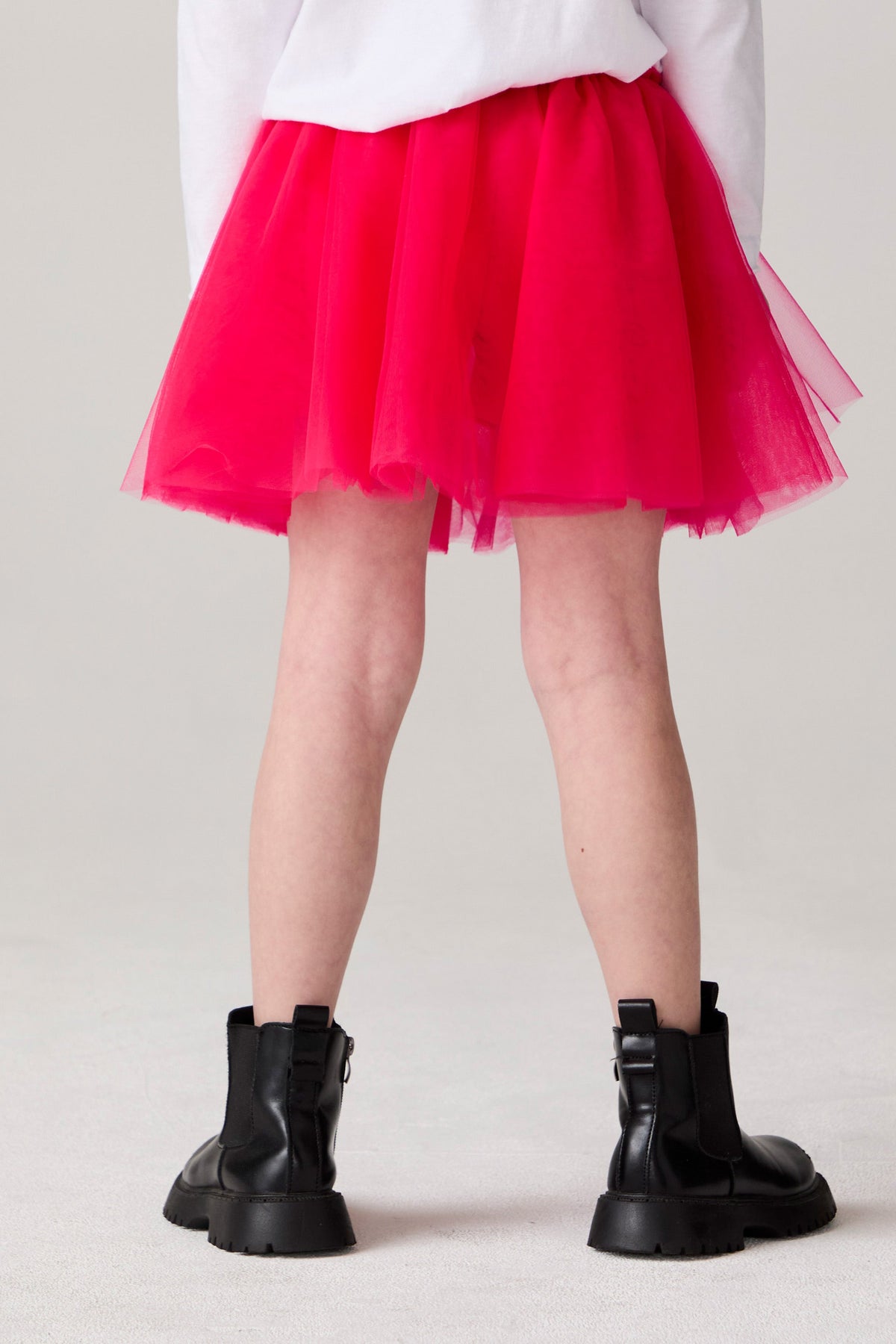 Model wearing Chaser's Holiday Ombre Girls Tulle Skort in hot bubble gum with distinctive graphic and design details, back view