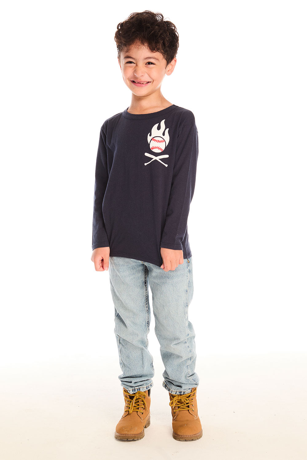 Full body view of boy wearing Chaser’s Bring The Heat black long-sleeve shirt with logo, light blue jeans, and brown boots on a white background.
