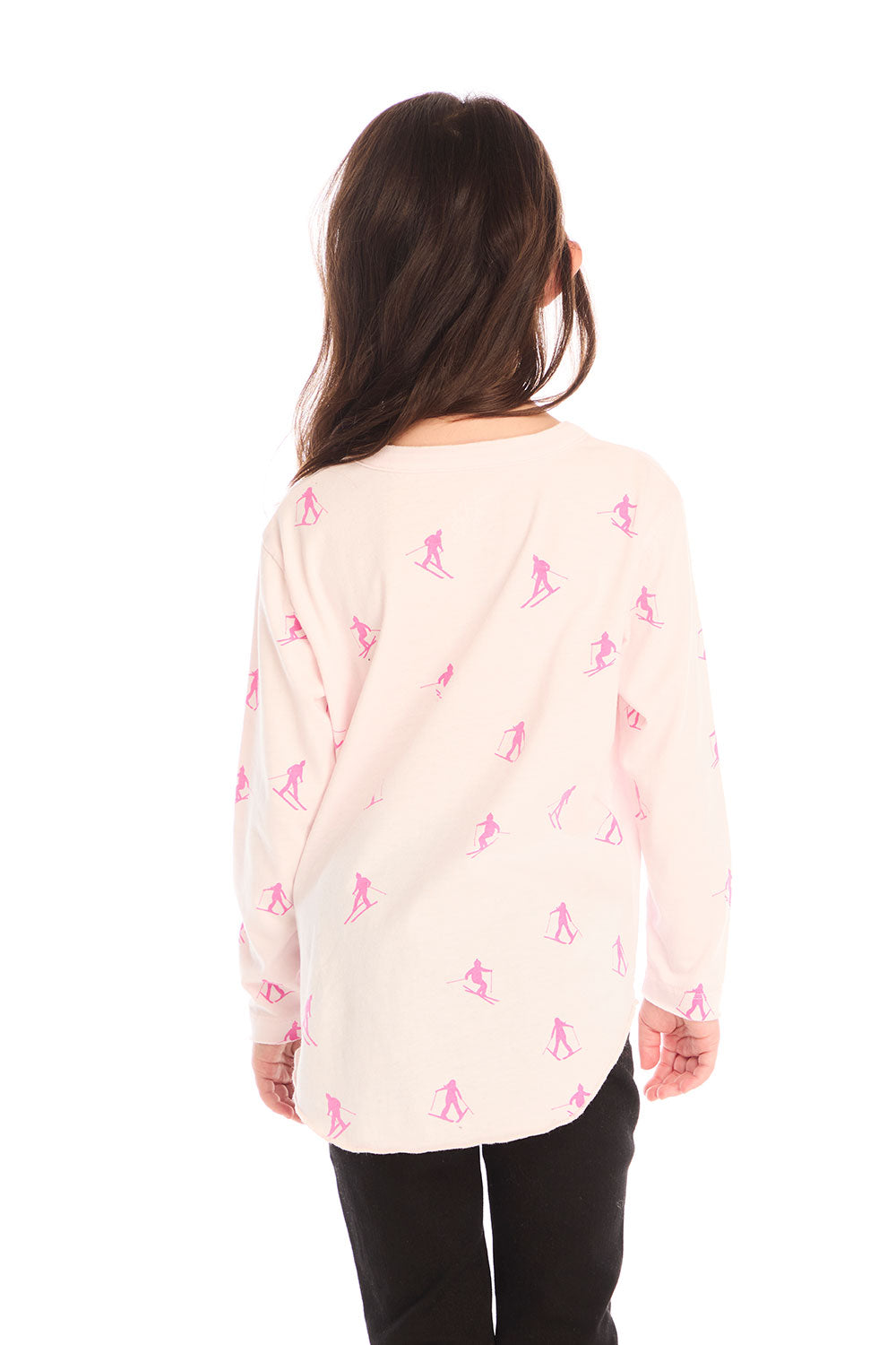 Back view of young girl wearing Chaser’s light pink Allover Pink Skiers long sleeve top with skier patterns on a white background