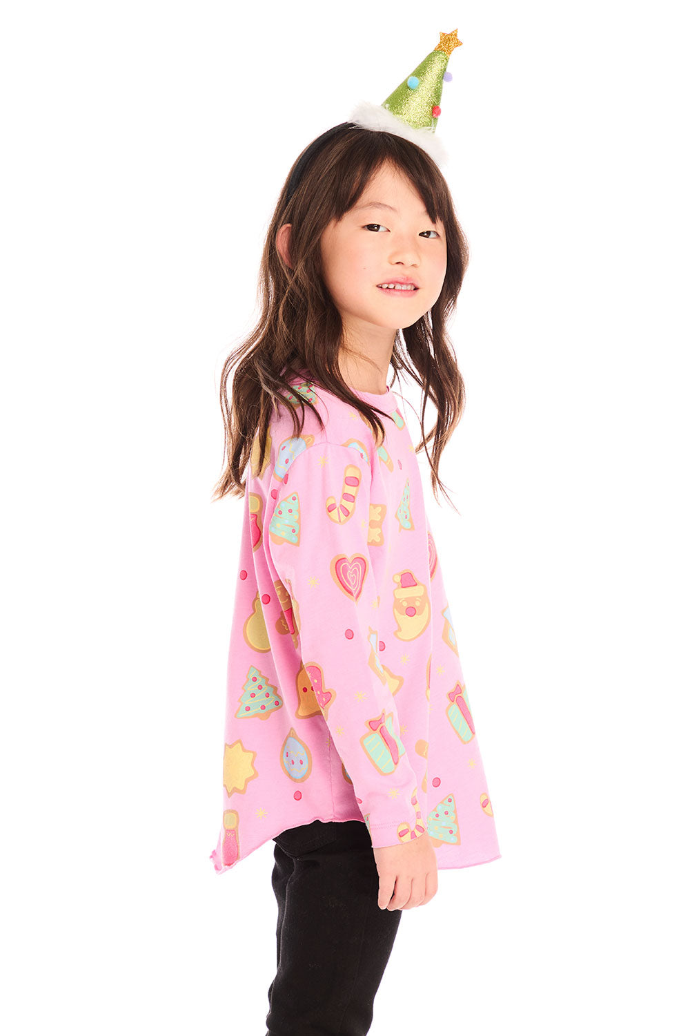  Side view of girl wearing Chaser’s pink Tossed Candy Canes Long Sleeve with candy cane patterns and a Christmas tree hat on a white background
