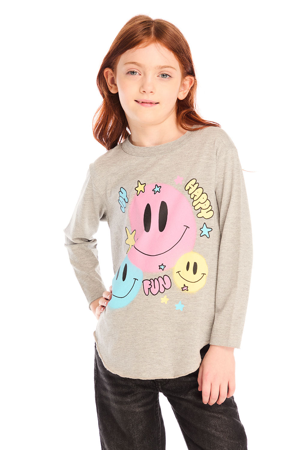 Girl wearing Chaser’s Heather Grey Colorful Smileys long sleeve pullover with colorful smiley face designs and black jeans on a white background