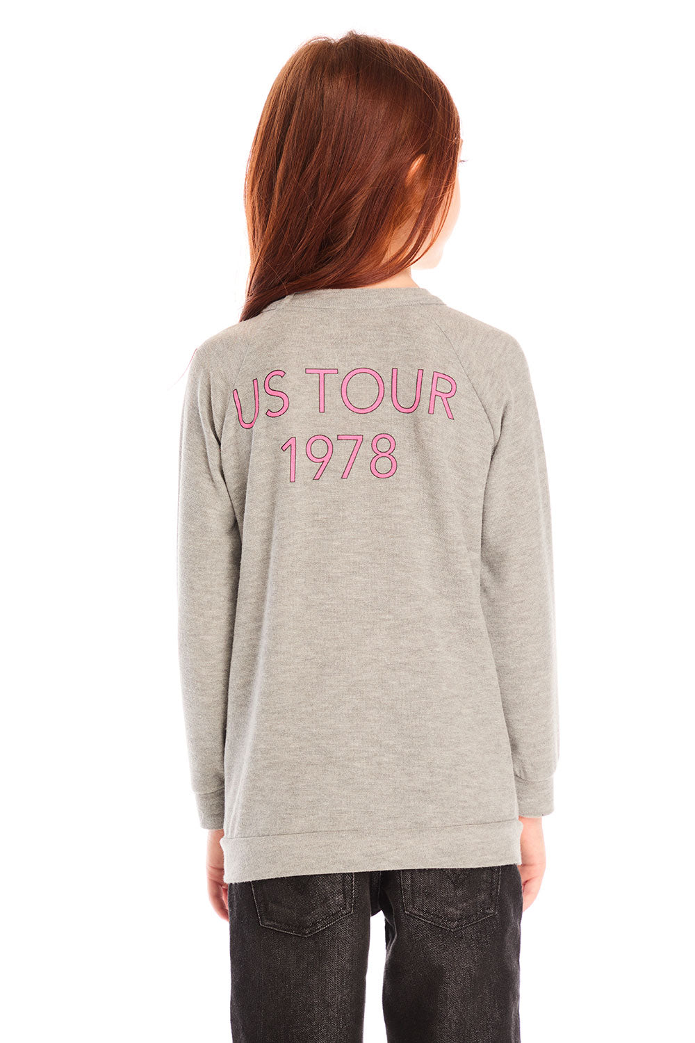 Back view of girl wearing Chaser’s gray The Rolling Stones Spiral Tongues Long Sleeve with “US TOUR 1978” text in pink on a white background