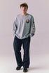 Full body view of model wearing Grateful Dead silver grey rainbow skull graphic long sleeve.