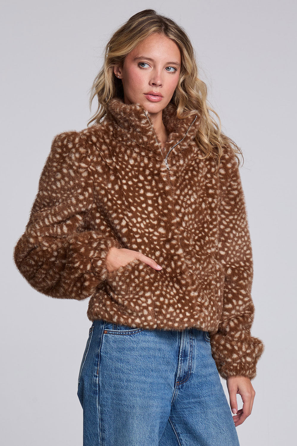 Model wearing Chaser's Baby Deer Puff Sleeve Jacket in warm brown spotted faux-fur texture with oversized puff sleeves, angled view