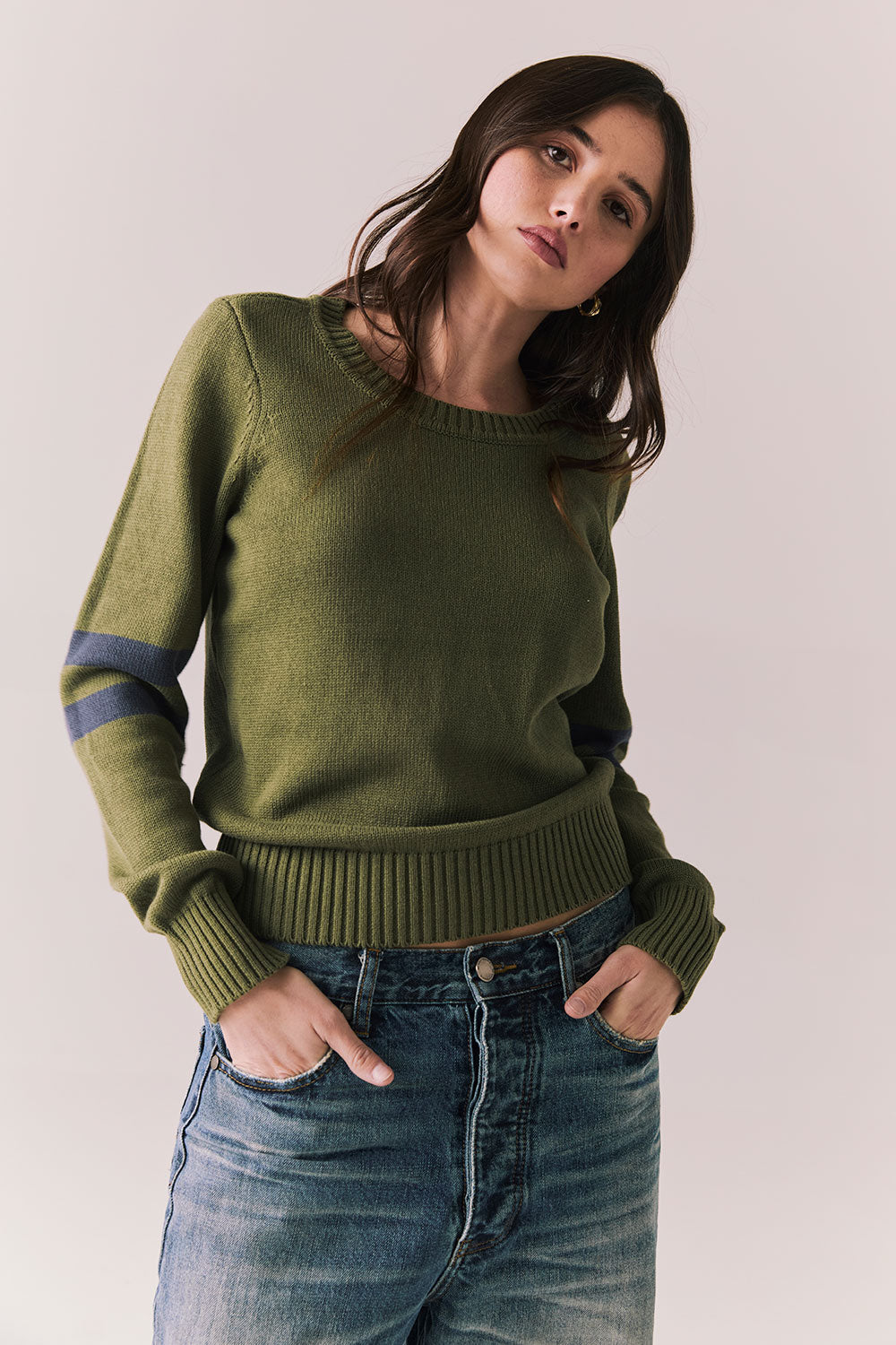 Front view of Varsity Star Sweater in bronze green with slouchy fit and twin arm stripes against a plain background