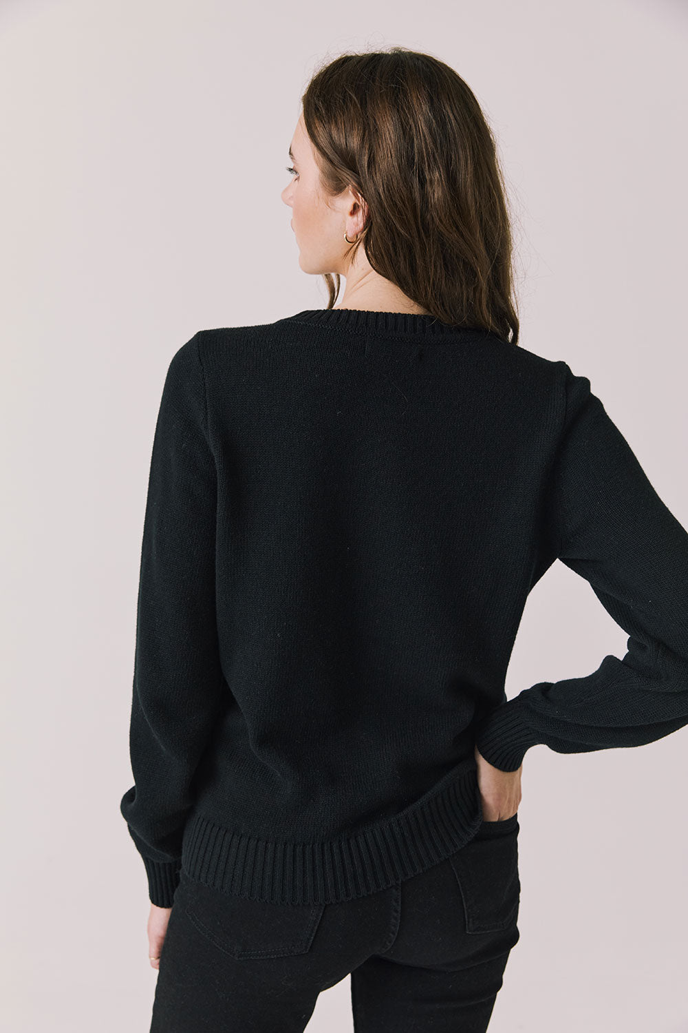 Back view of woman wearing Chaser’s true black Bow Long Sleeve on a plain background.