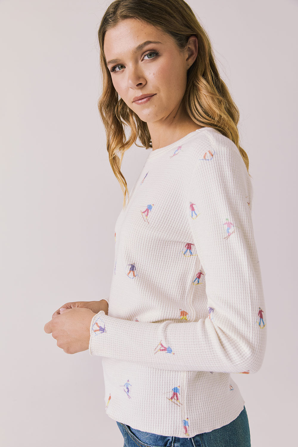 Side view of woman wearing Chaser's Allover Skiers  with small colorful patterns on a light gray background
