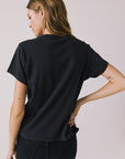 Back view of woman wearing Chaser’s The Rolling Stones The British Are Coming Tee in True Black on a plain background