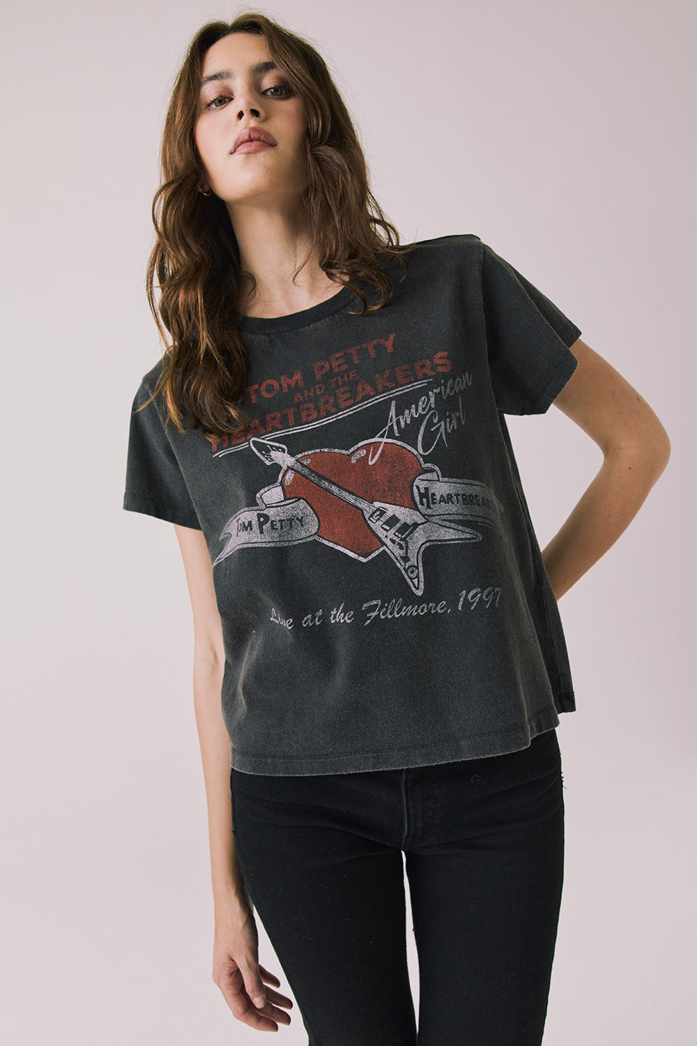Front view of woman wearing Chaser’s Tom Petty Live At The Fillmore Tee with vintage concert graphic on a plain background