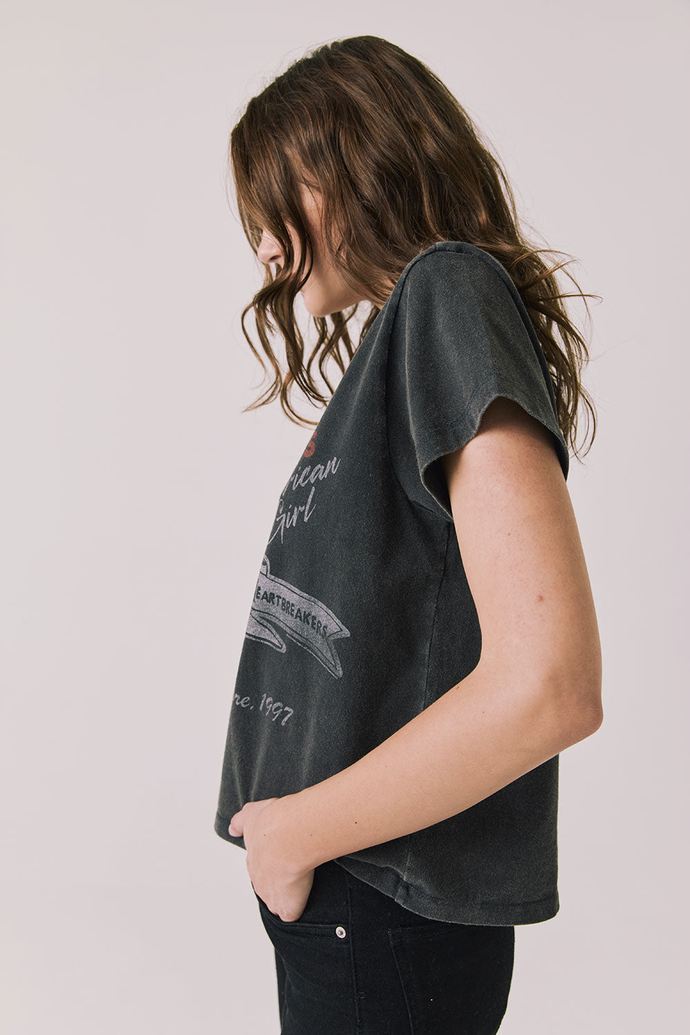 Side view of woman wearing Chaser’s Tom Petty Live At The Fillmore Tee on a plain background