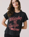 Front view of woman wearing Chaser’s Whiskey A Go Go Classic Neon Logo black Tee with red neon-style text on a light background