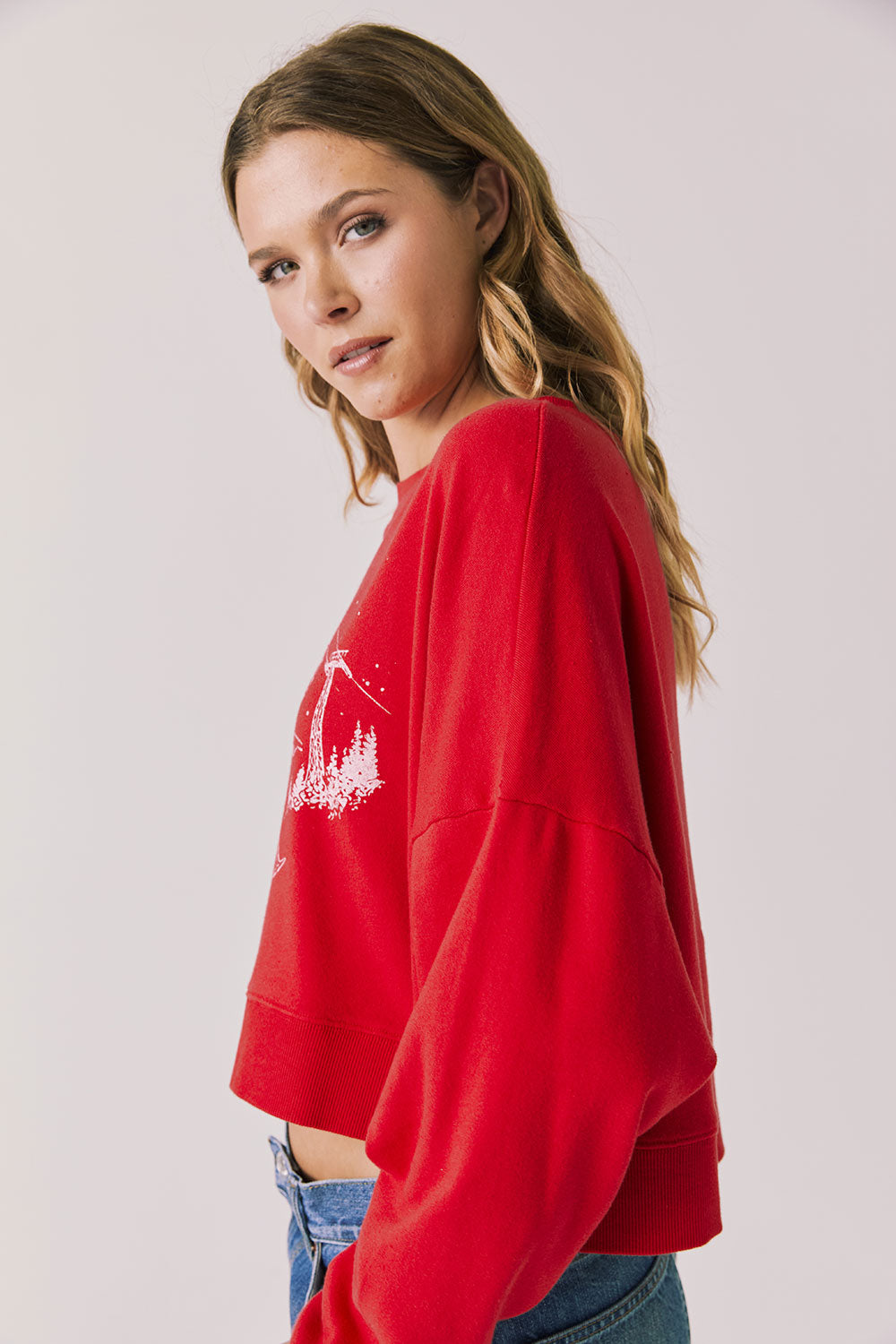 Side view of woman wearing Chaser's red Apres Ski Cheers with graphic design on a plain background
