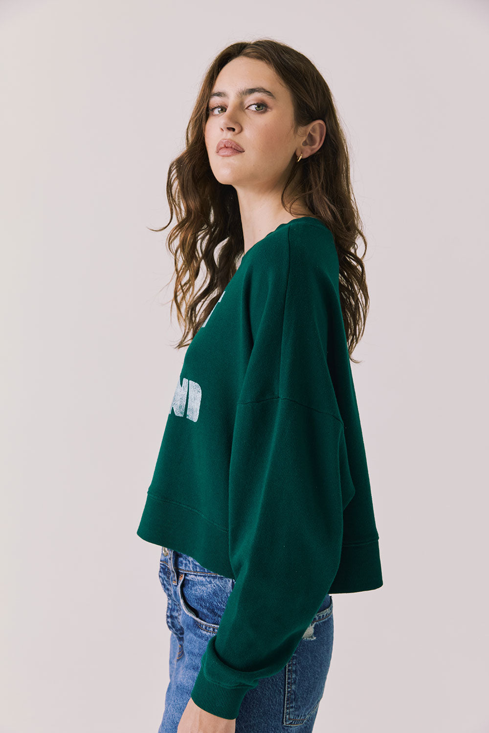 Side view of woman wearing Chaser’s Blue Grass Green C’est Le Weekend Long Sleeve with relaxed fit on a plain background