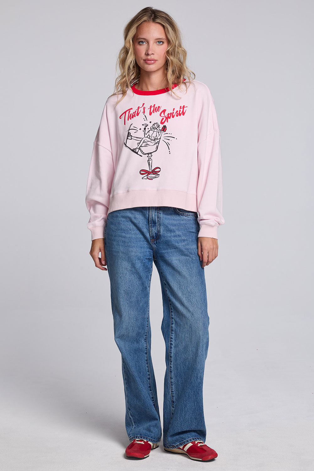 Model wearing Chaser's Champagne Party Pullover in Pinky pink with festive champagne glass artwork, full-body view
