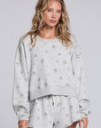 Model wearing Chaser's Twilight Pullover in Heather Grey with scattered black stars and spark details, front view