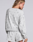 Model wearing Chaser's Twilight Pullover in Heather Grey with scattered black stars and spark details, back view