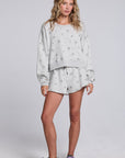 Model wearing Chaser's Twilight Pullover and matching Twilight Shorts in Heather Grey with scattered black stars and spark details, full-body view