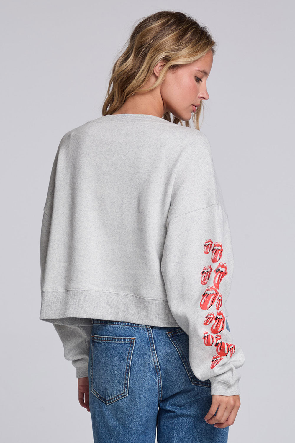 Model wearing Chaser's Rolling Stones Tattoo You Pullover in Heather Grey with colorful Rolling Stones Tattoo You artwork and red sleeve graphics, back view