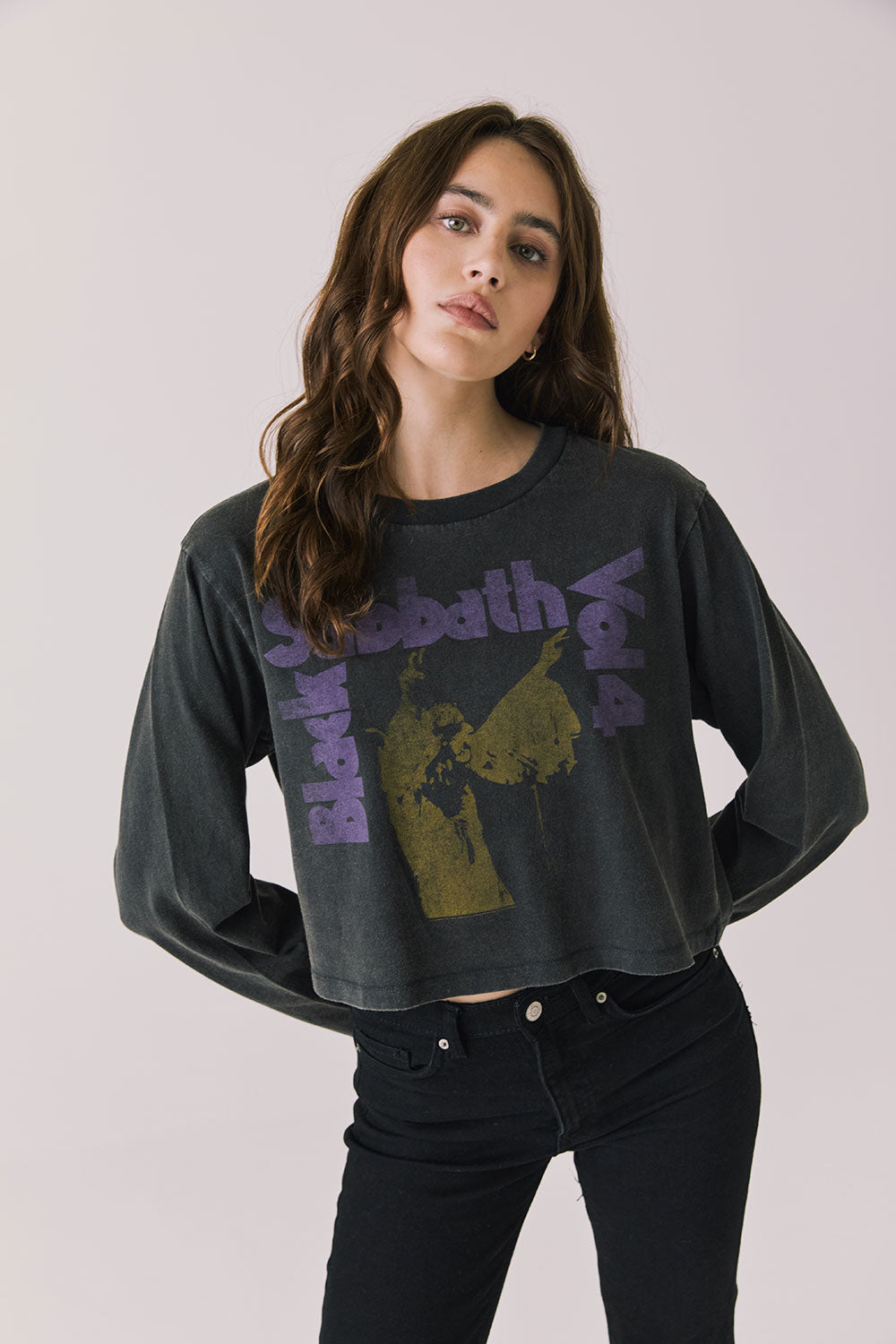 Woman wearing Chaser's black oversized Black Sabbath Vol 4 Long Sleeve top with a graphic design, black pants on a white background