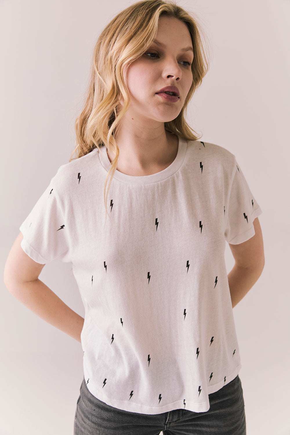 Front view of Tossed Bolts short sleeve tee in white with scattered black lightning bolt graphic and relaxed fit against a plain background