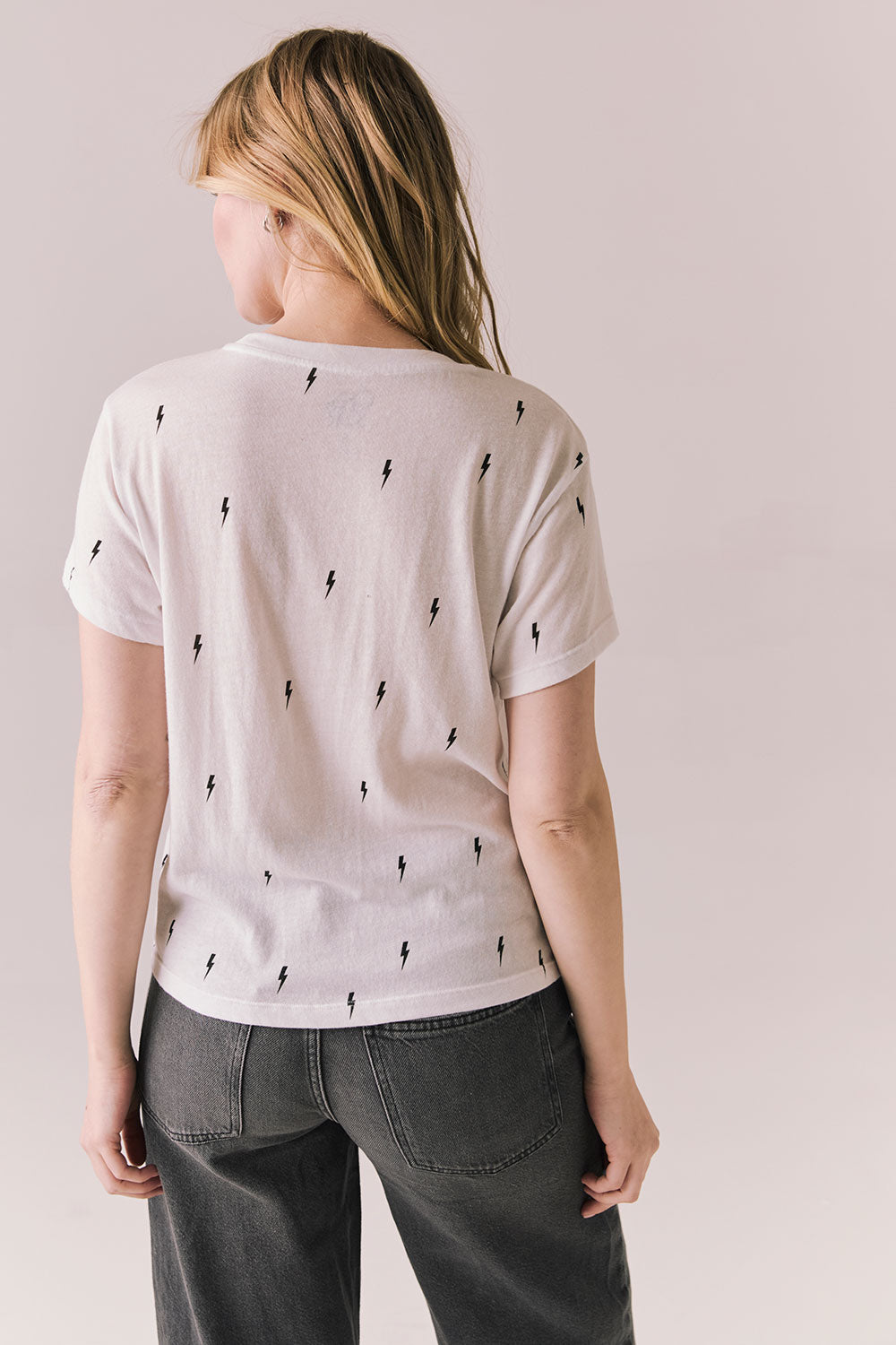 Back view of Tossed Bolts short sleeve tee in white with scattered black lightning bolt graphic and relaxed fit against a plain background