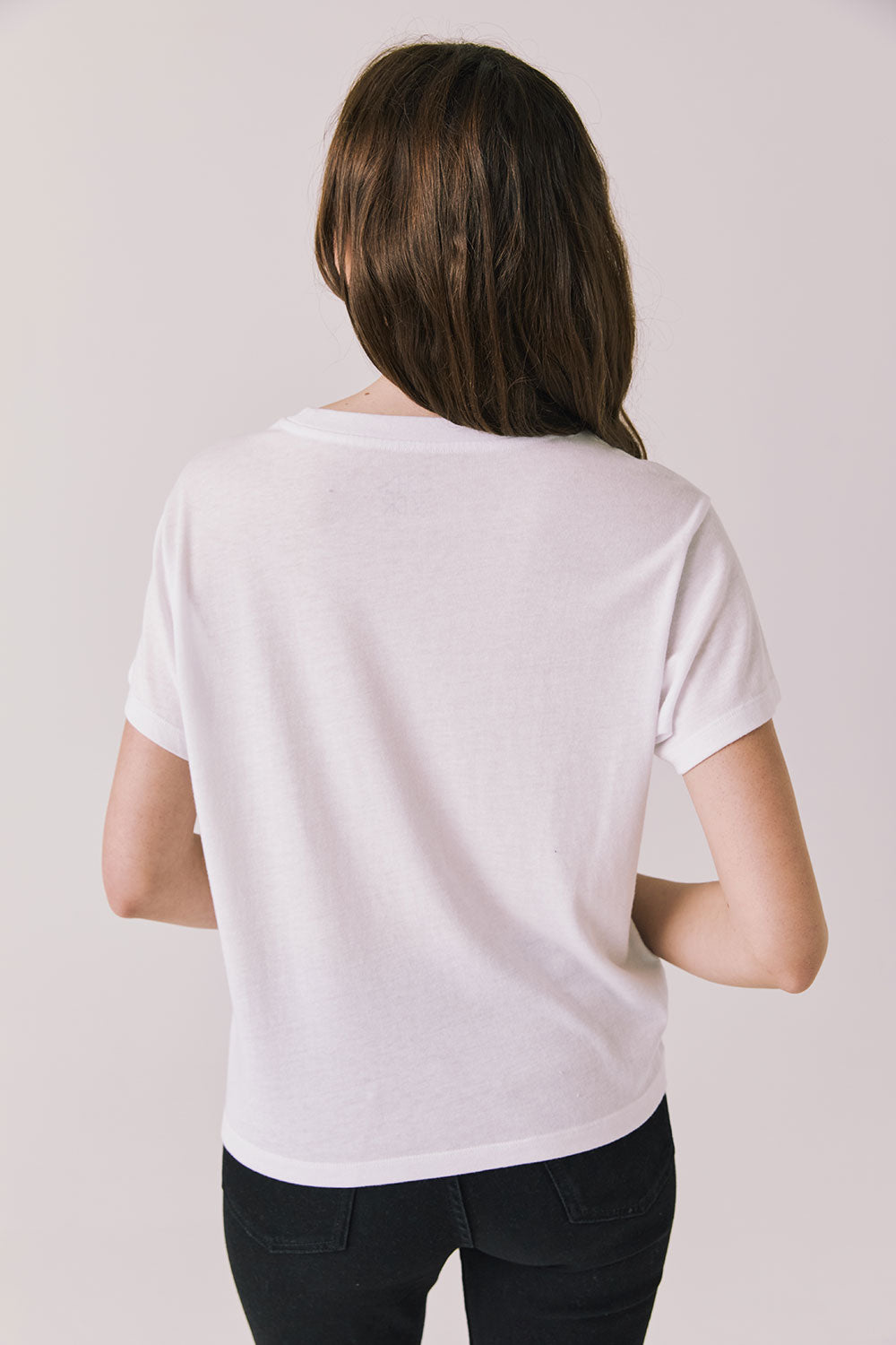 Back view of woman wearing Chaser's white “Roma Italia” Italian graphic tee on a light background