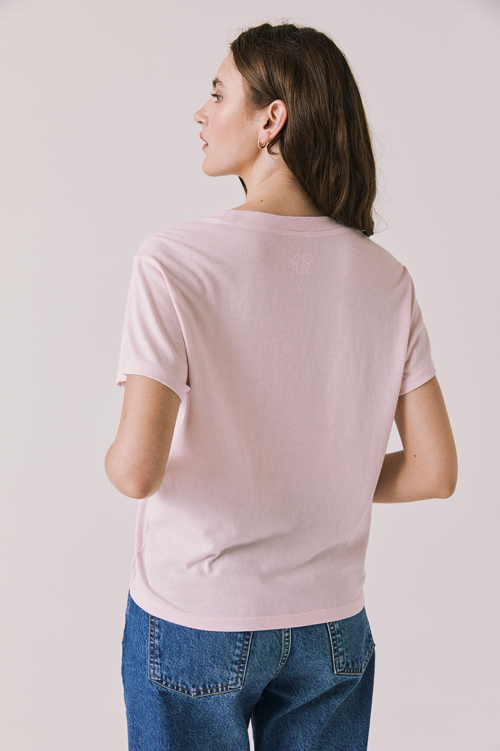 Back view of woman wearing Chaser’s Semi Sweet Pink Tee on a light background