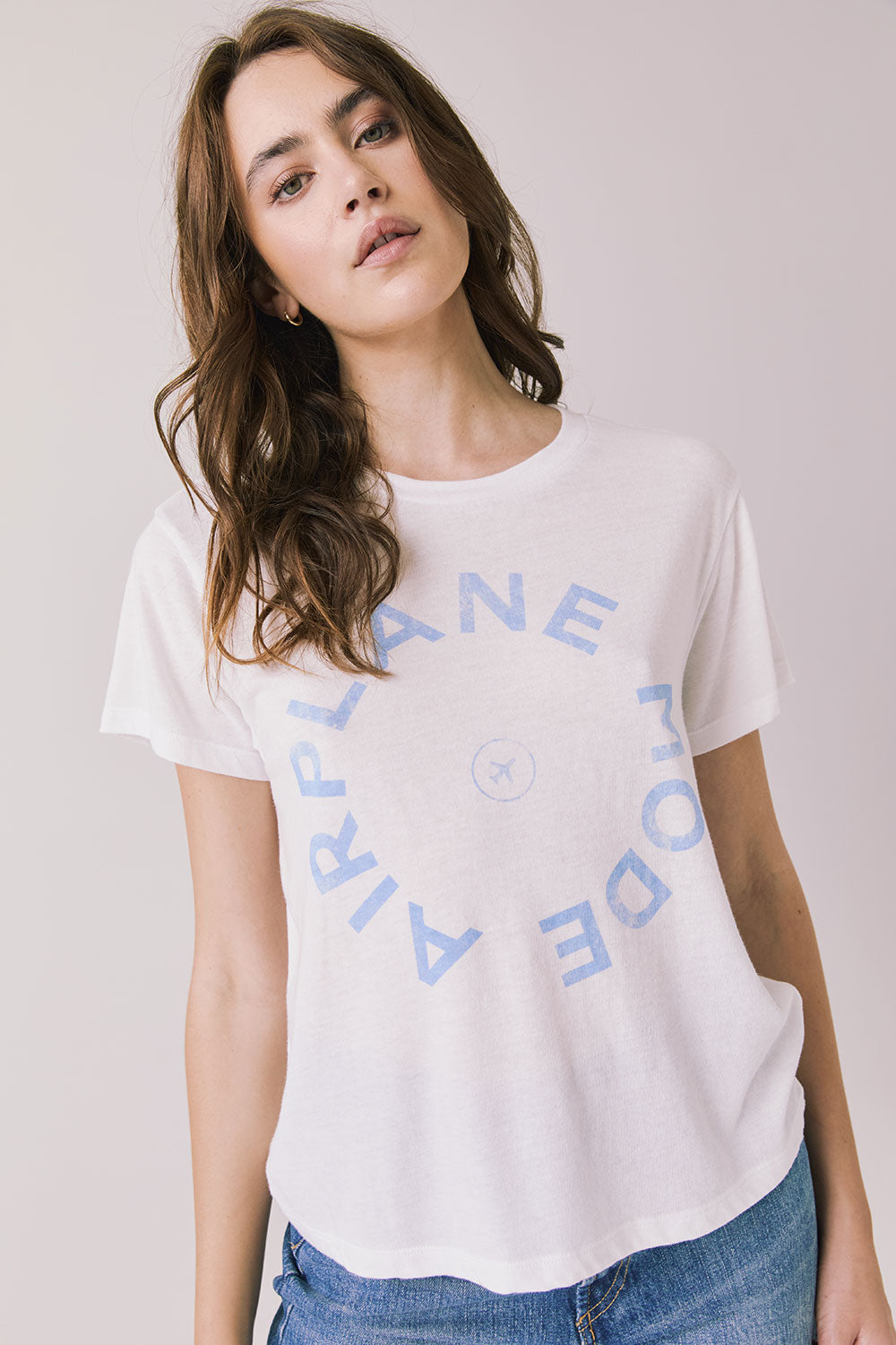 Woman wearing the Airplane Mode Tee with blue text on a plain background