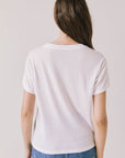 Back view of woman wearing the Airplane Mode Tee on a plain background