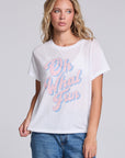 Model wearing Chaser's Oh What Fun Tee in White with pastel Oh What Fun holiday lettering, front view