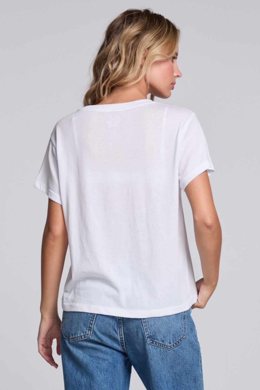 Model wearing Chaser's Oh What Fun Tee in White with pastel Oh What Fun holiday lettering, back view