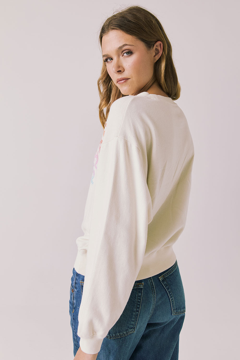 Back view of woman wearing Chaser’s The Beatles Come Together Starry White Long Sleeve on a plain background