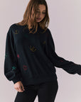 Front view of model wearing Allover Icons Long Sleeve in black
