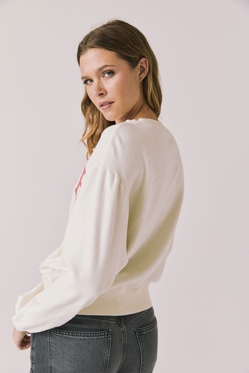 Back view of woman wearing Chaser’s starry white Bonjour Long Sleeve on a plain background.