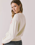 Back view of woman wearing Chaser’s starry white Bonjour Long Sleeve on a plain background.