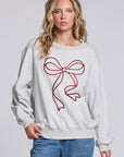 Model wearing Chaser's Merry Bow Pullover in Heather Grey with oversized red bow artwork, front view