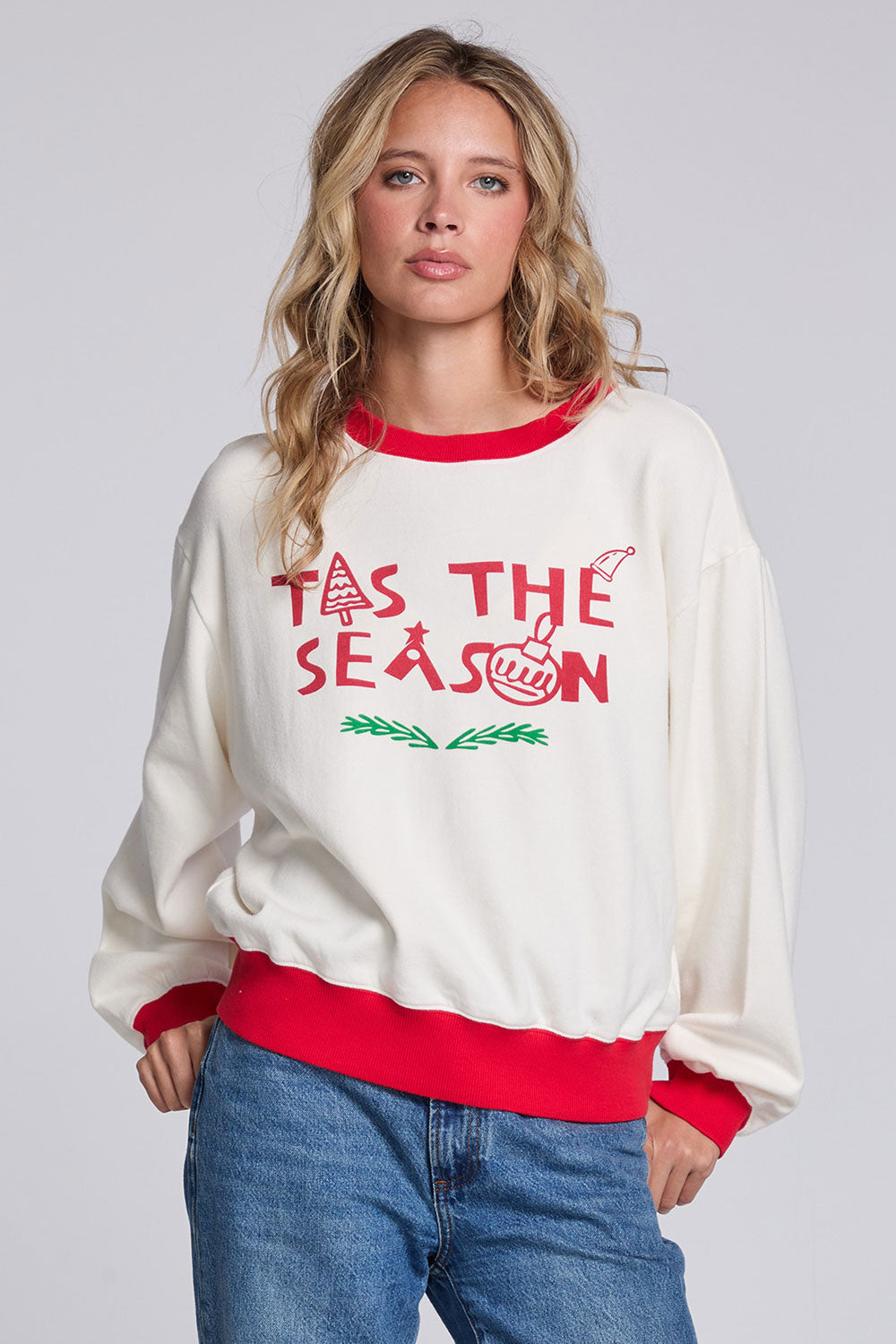 Model wearing Chaser's 'Tis the Season Pullover in Whisper White with red and green 'Tis the Season lettering and red trim, front view